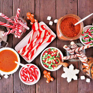 A spread of Hot Cocoa mix and other ingredients and toppings like marshmallows, peppermint canes, candy, caramel, and more!