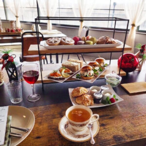 Afternoon Tea set up in tiers with tea sandwiches, scones, and desserts on the top tier.