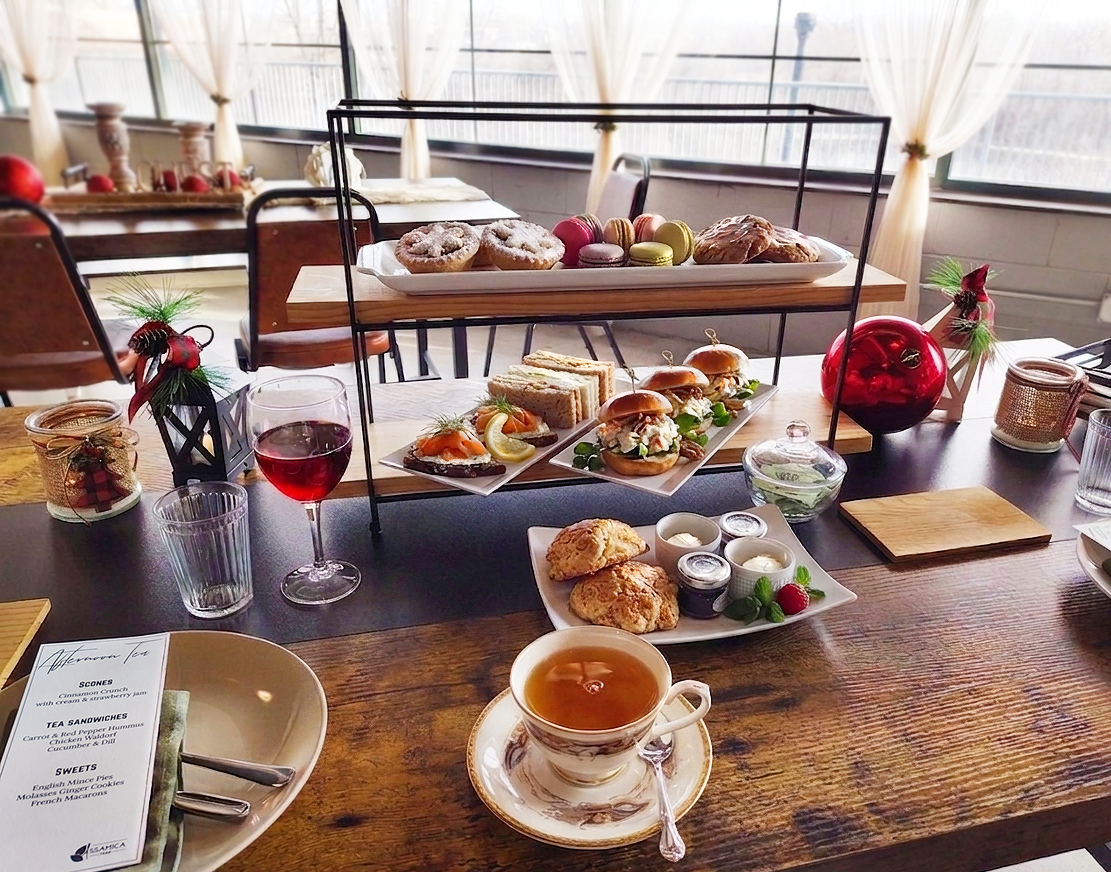 Afternoon Tea set up in tiers with tea sandwiches, scones, and desserts on the top tier.
